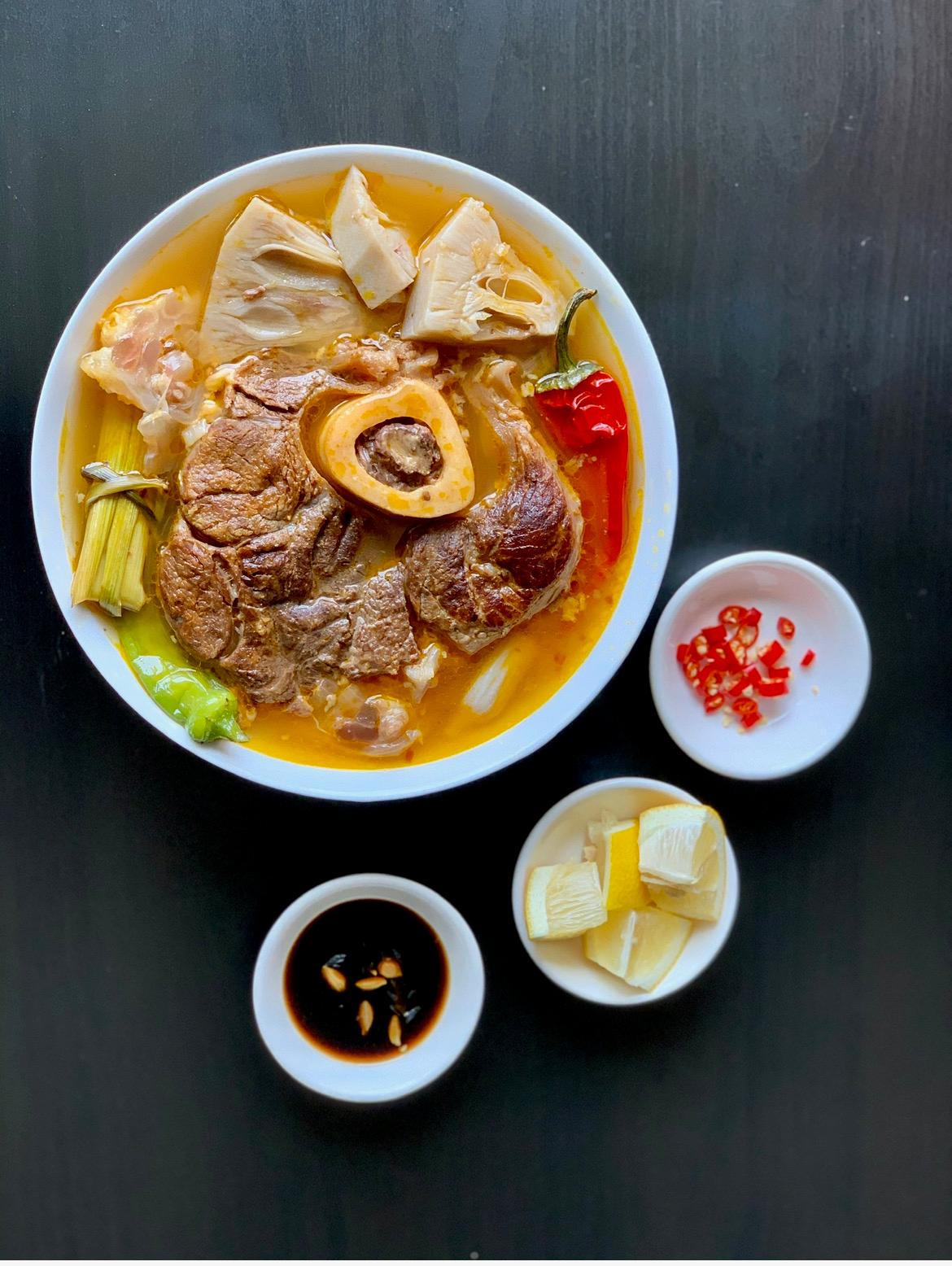 Bowl of beef shank soup with marrow bone, lemongrass, chilies