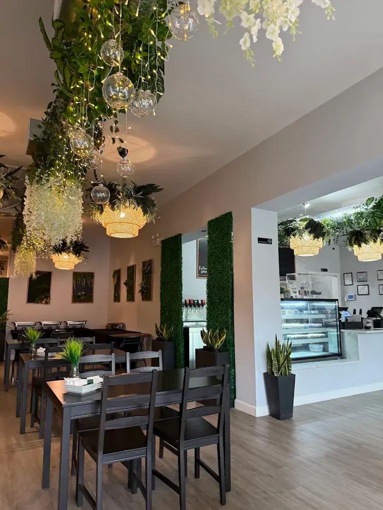 Casual dining area with hanging plants, woven pendant lights, and tables